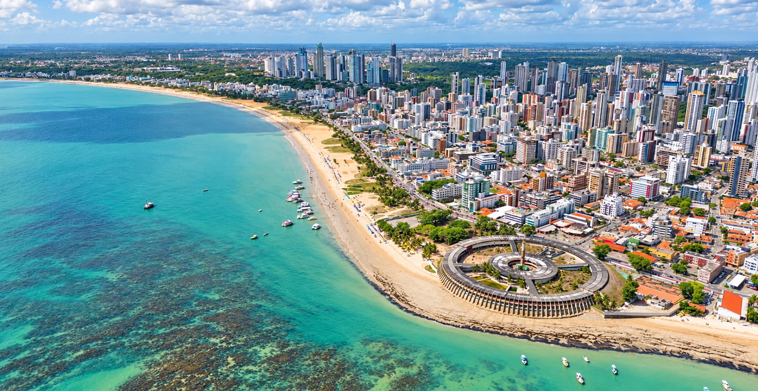 Vista aérea da orla de João Pessoa, com mar, faixa de areia e skyline urbano